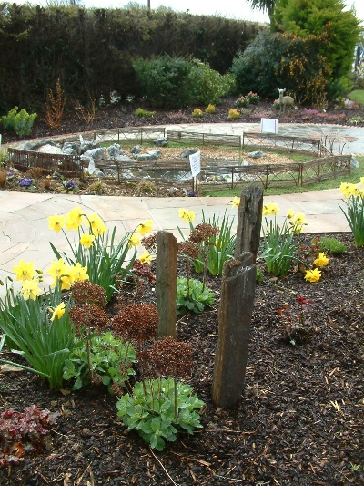 garden design Island bed with wispy grasses three obelisks and a large pond