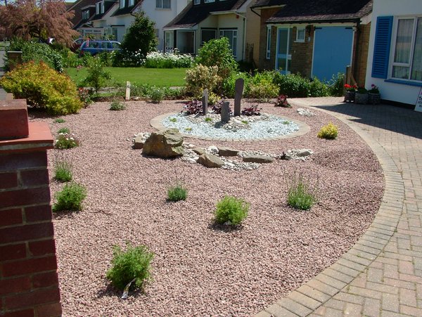 garden design Stripy lawn round sandstone patio