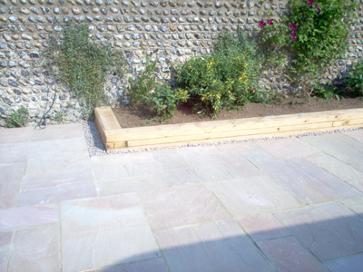 patio_rustington_indian_sandstone_flower_boarder_wooden_sleeper_surround.jpg